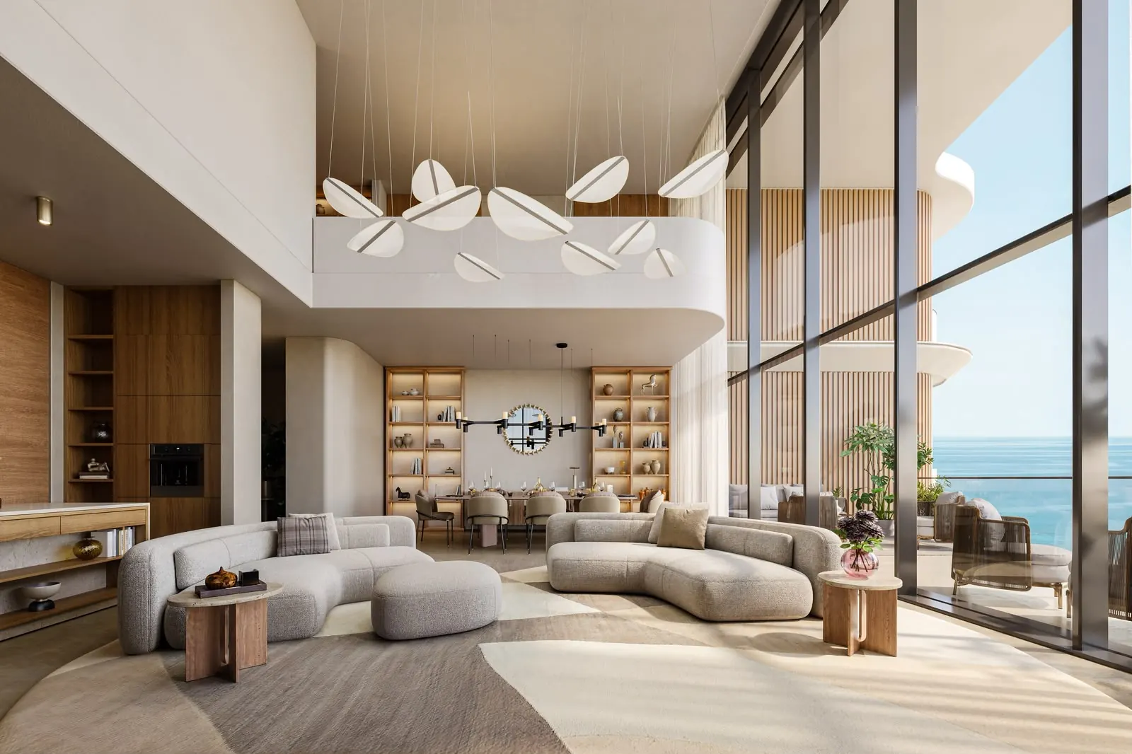 Double-height living room with curved sofas, sculptural pendant lights and floor-to-ceiling windows facing the sea